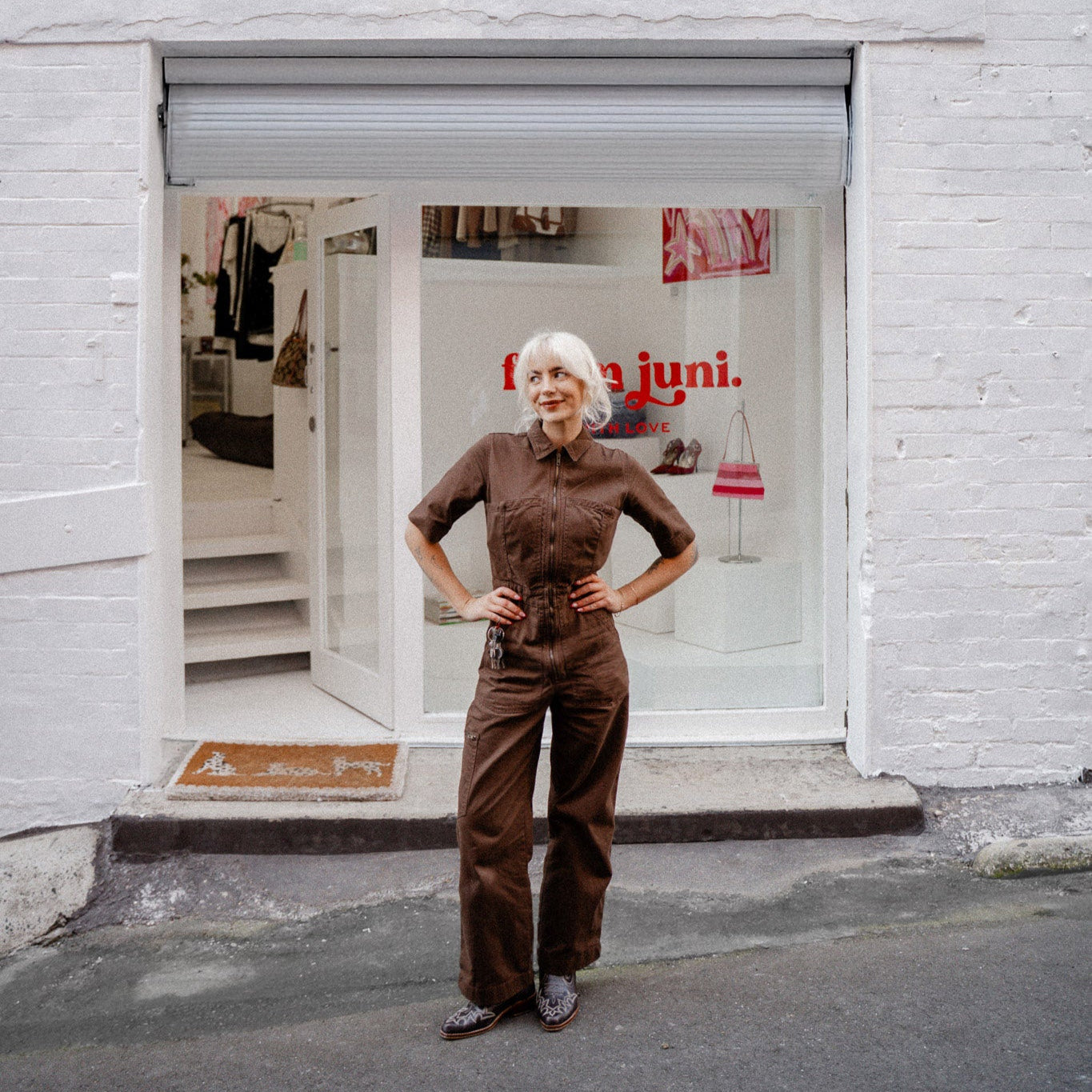Woman standing in front of a store with 'from juni' branding.